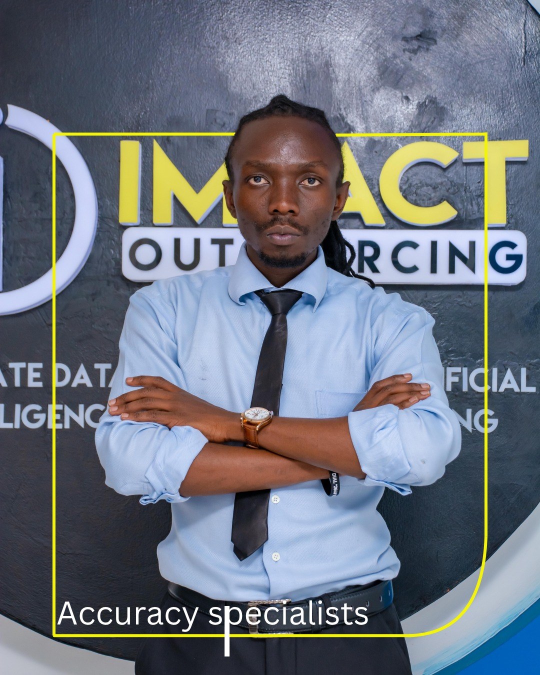 An Impact Outsourcing accuracy specialist at the company's Nairobi facility, photographed in front of the Impact Outsourcing logo wall.