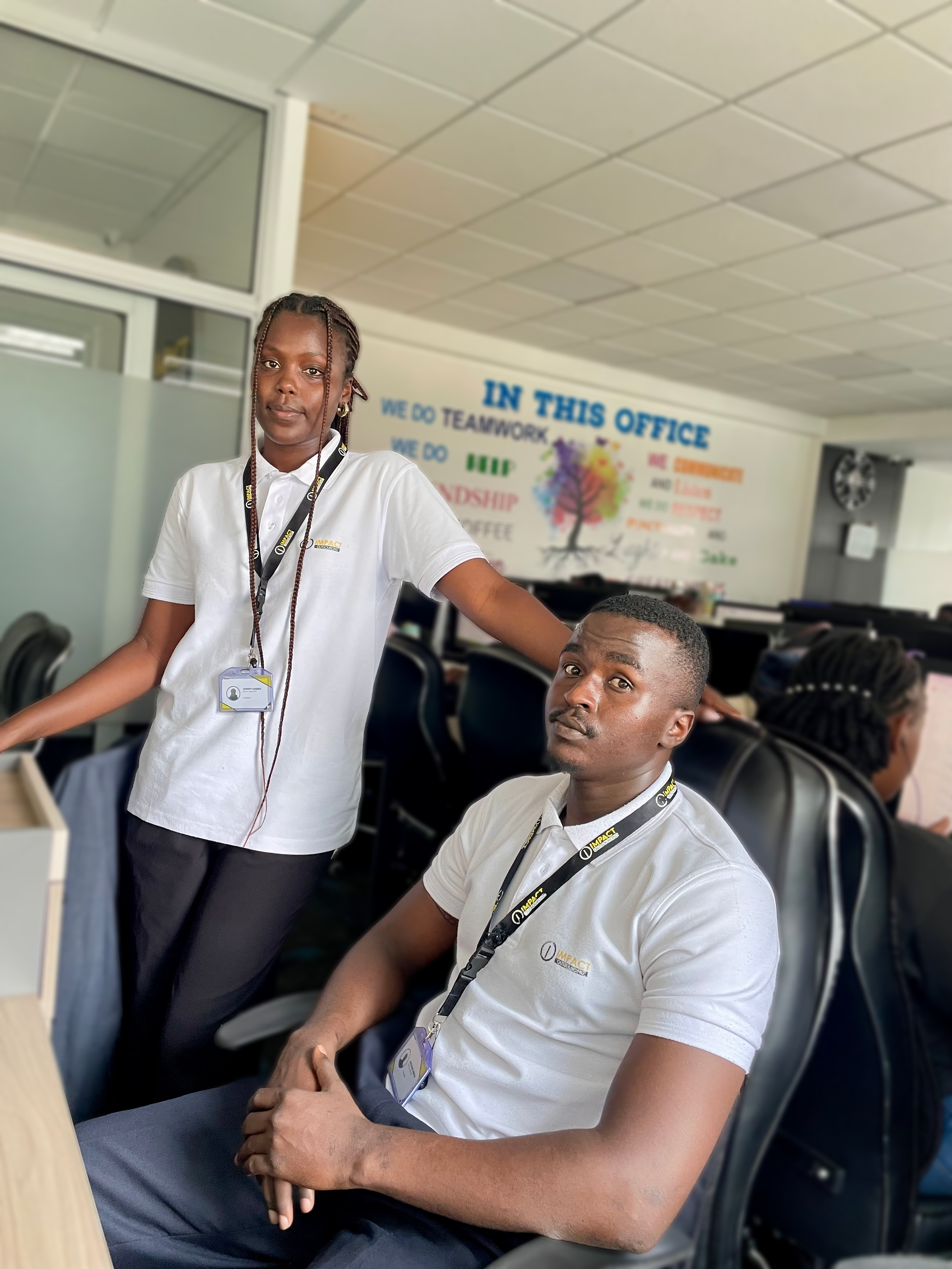 Two Impact Outsourcing operators in branded uniform on the delivery floor in Nairobi.
